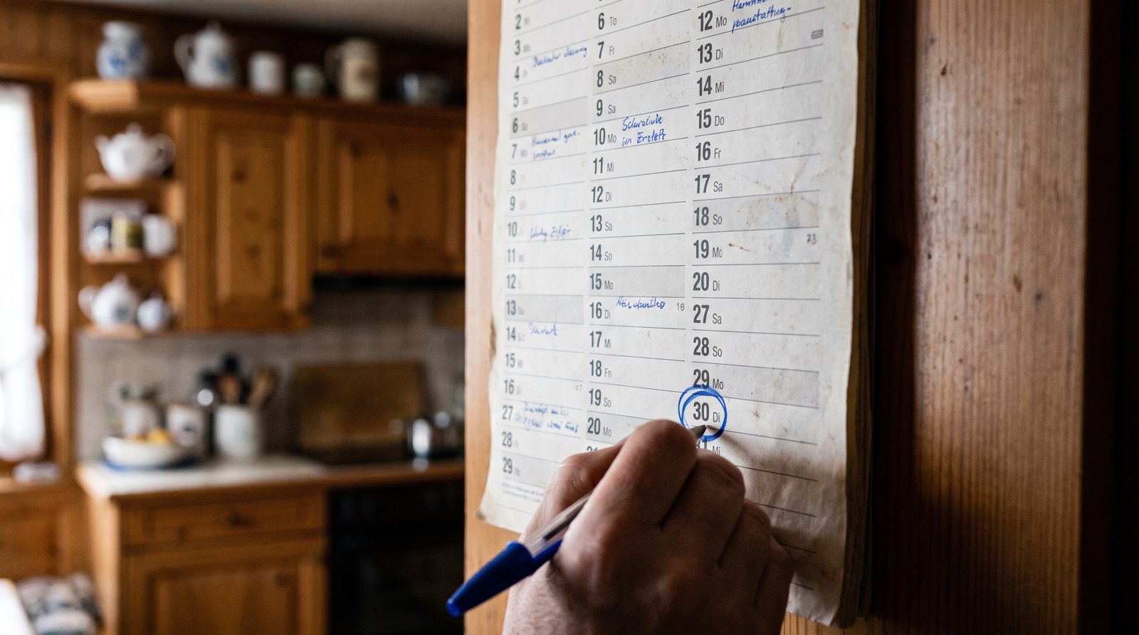 Un calendrier mural de novembre avec le 30 entouré, dans une cuisine romande